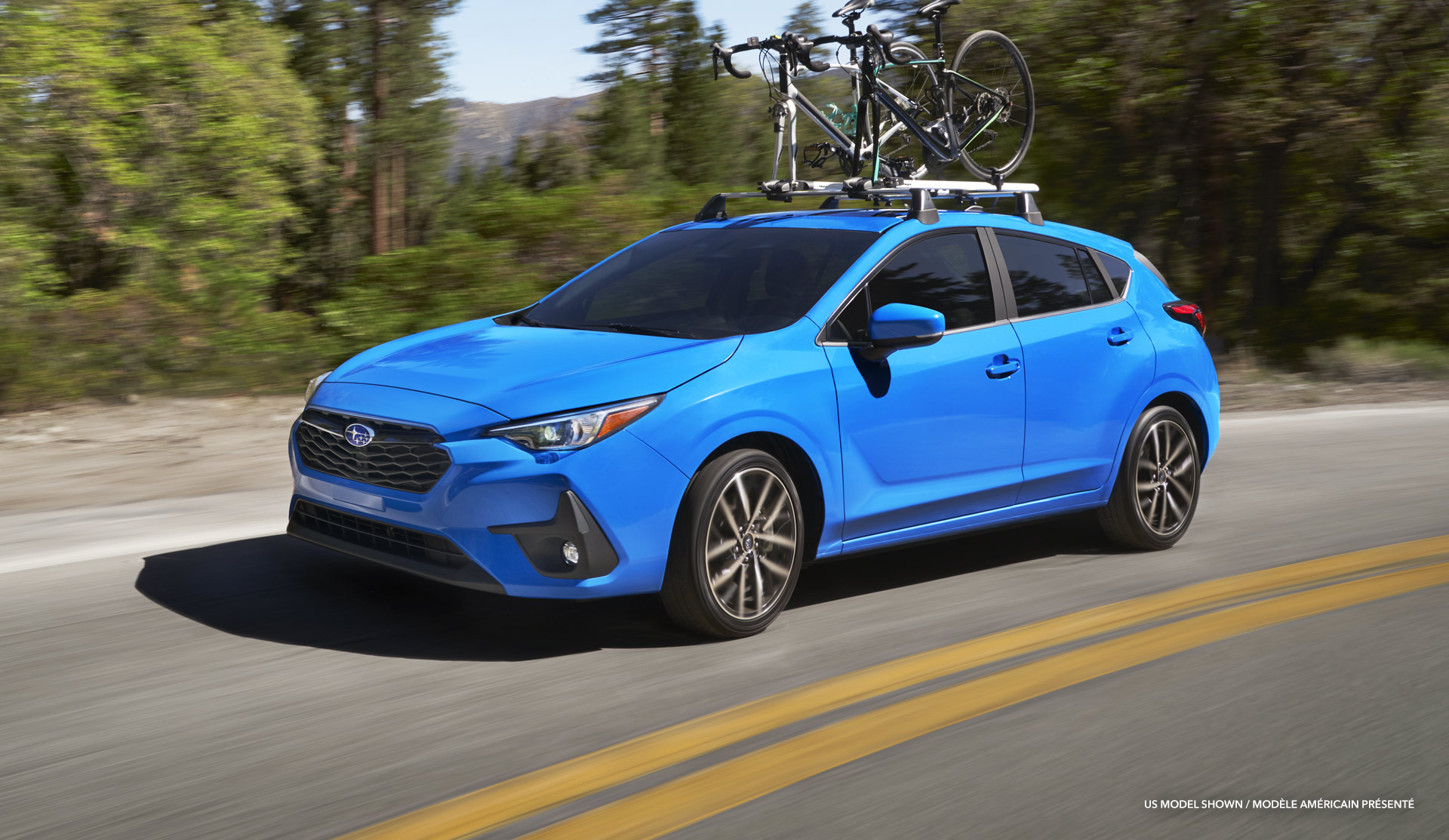 Impreza RS 2024 avec des vélos sur le toit, roulant sur une route.